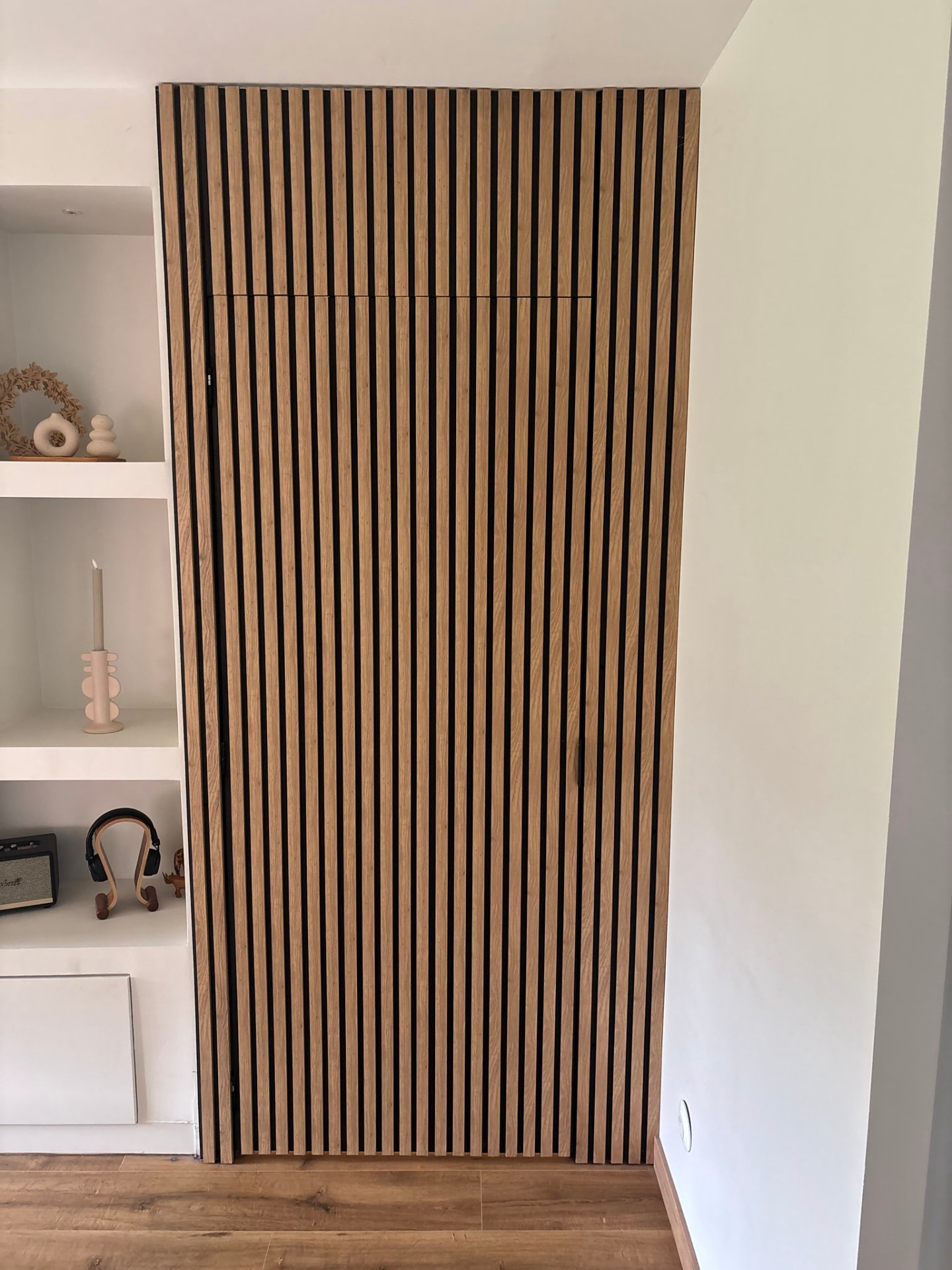 Mur en tasseaux de bois avec porte invisible intégrée