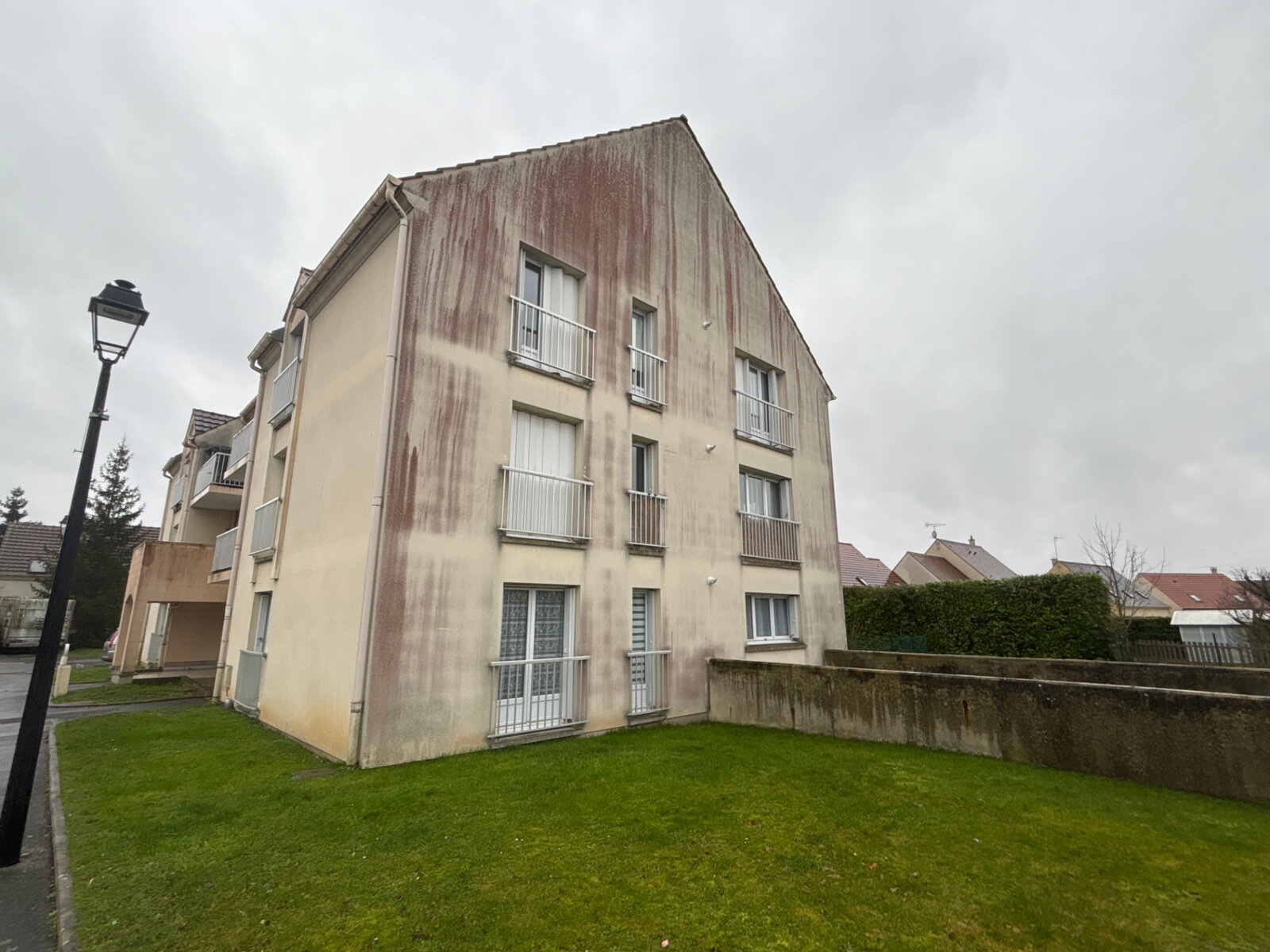 Pignon d'une résidence collective à Clairoix fortement encrassé par les coulures avant nettoyage de façade
