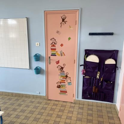Porte de classe repeinte en rose pastel avec décoration enfants à l'école Goincourt