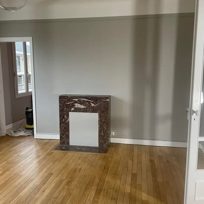 Pièce avec cheminée à Beauvais : parquet vitrifié et peinture murale harmonisée